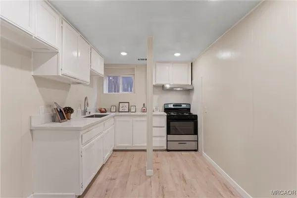 a kitchen with a sink a stove and cabinets