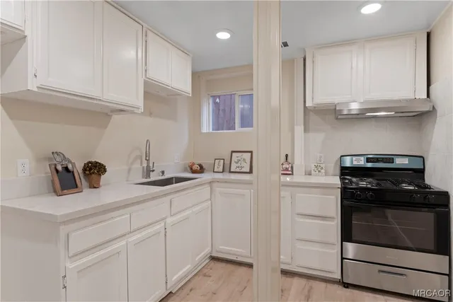 a kitchen with white cabinets and appliances