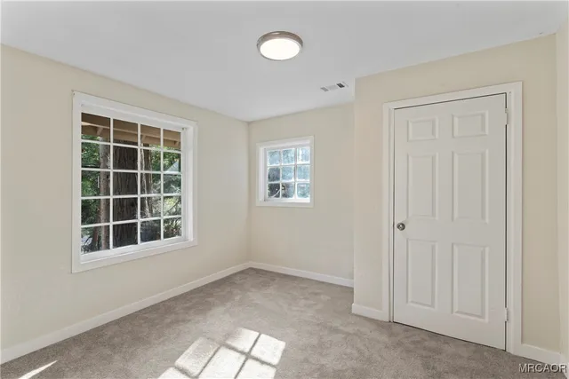 an empty room with windows and closet