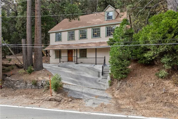 an aerial view of a house with a yard and large trees