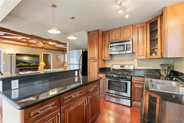a kitchen with stainless steel appliances granite countertop a stove a sink and a microwave