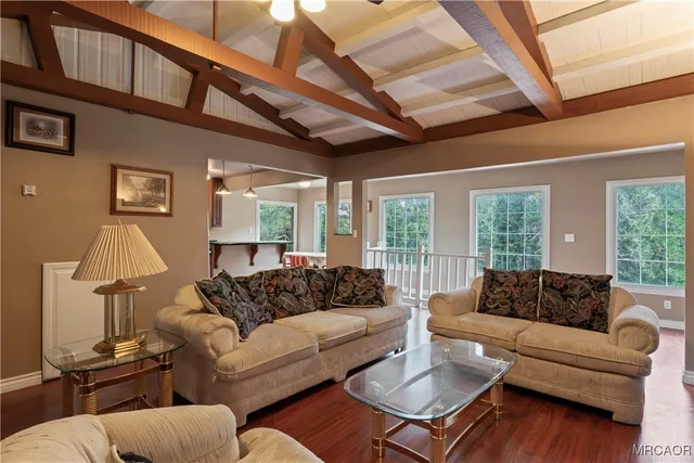 a living room with furniture a large window and a table