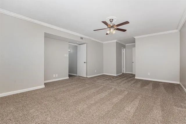 a view of a big room with ceiling fan and window