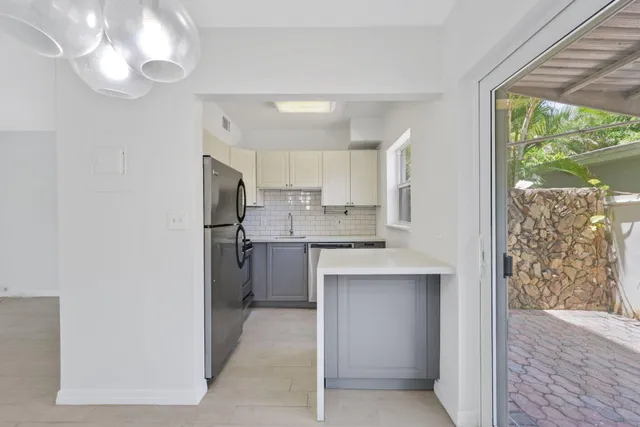 a kitchen with kitchen island white cabinets and refrigerator