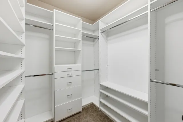 a view of walk in closet with empty racks