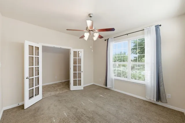a view of a livingroom with a ceiling fan and window