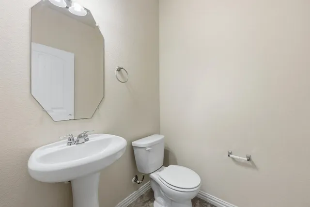 a bathroom with a sink a toilet and a mirror