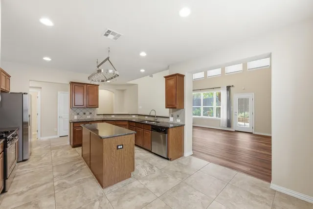 a kitchen with stainless steel appliances granite countertop a stove and a sink