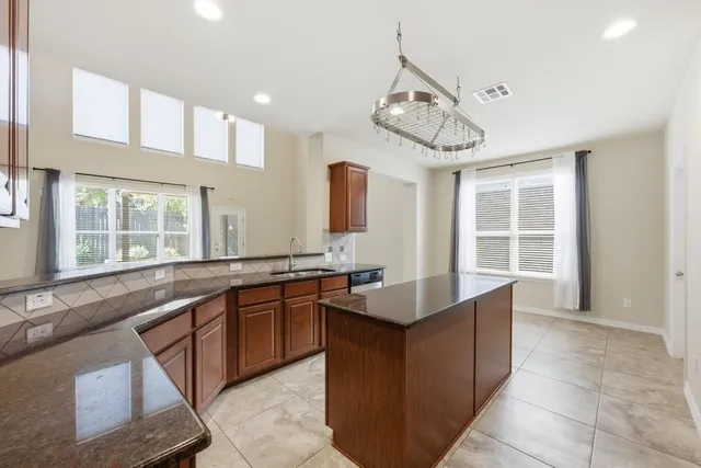 a large kitchen with a large counter space cabinets and stainless steel appliances
