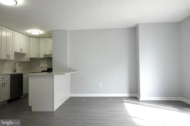 a kitchen with granite countertop white cabinets and wooden floor
