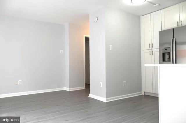 a view of a kitchen with refrigerator and wooden floor