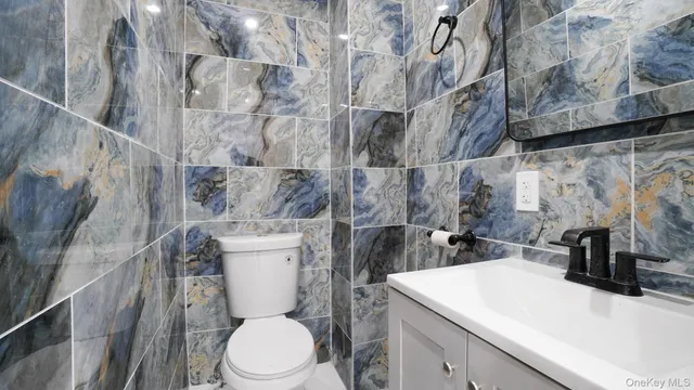 a bathroom with a toilet sink and mirror