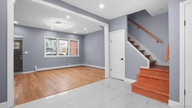 a view of an empty room with stairs and a window