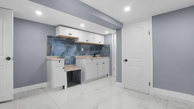 a view of a kitchen with white cabinets and white appliances