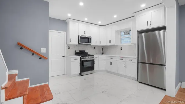a kitchen with white cabinets and white appliances