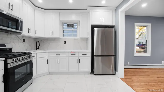 a kitchen with stainless steel appliances granite countertop a refrigerator sink and stove
