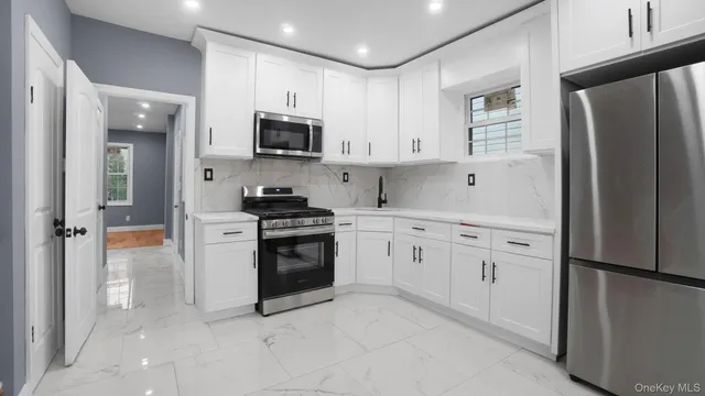 a kitchen with white cabinets and stainless steel appliances