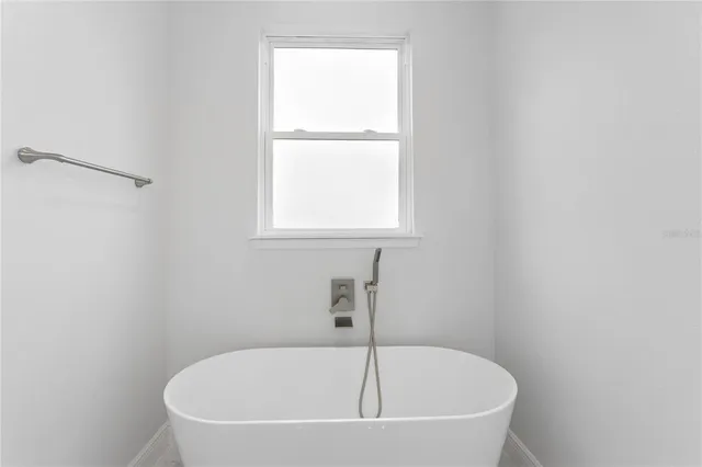 a white bath tub sitting next to a window
