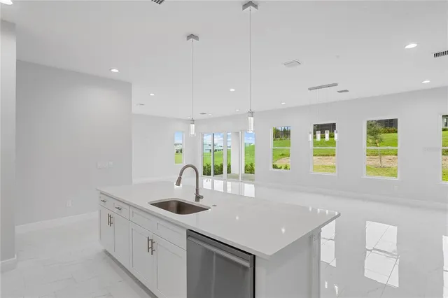 a kitchen with stainless steel appliances granite countertop a sink and a large window