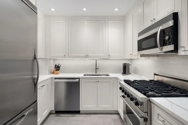 a kitchen with stainless steel appliances granite countertop a sink stove and microwave