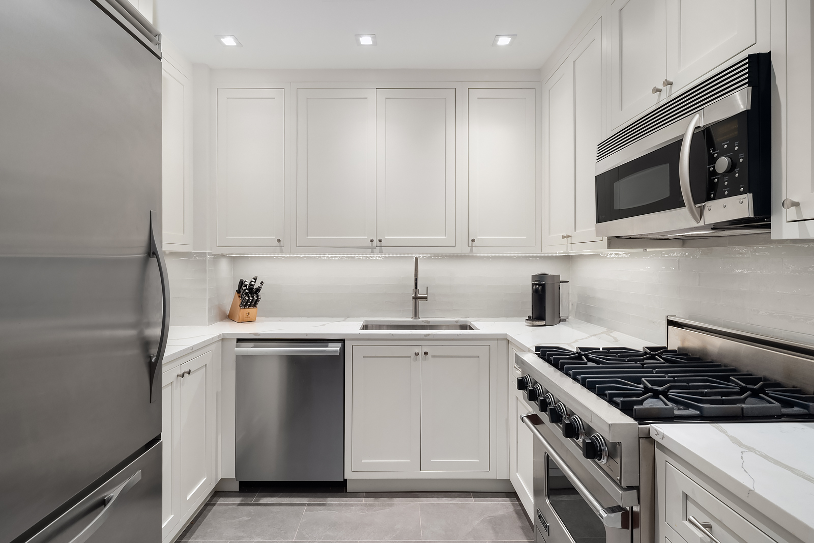 181 East 90th Street, Unit 4A Manhattan, NY 10128 - Photo 5 of 10 a kitchen with stainless steel appliances granite countertop a sink stove and microwave