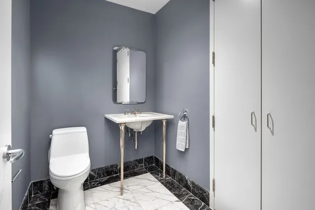 a bathroom with a toilet a sink and mirror