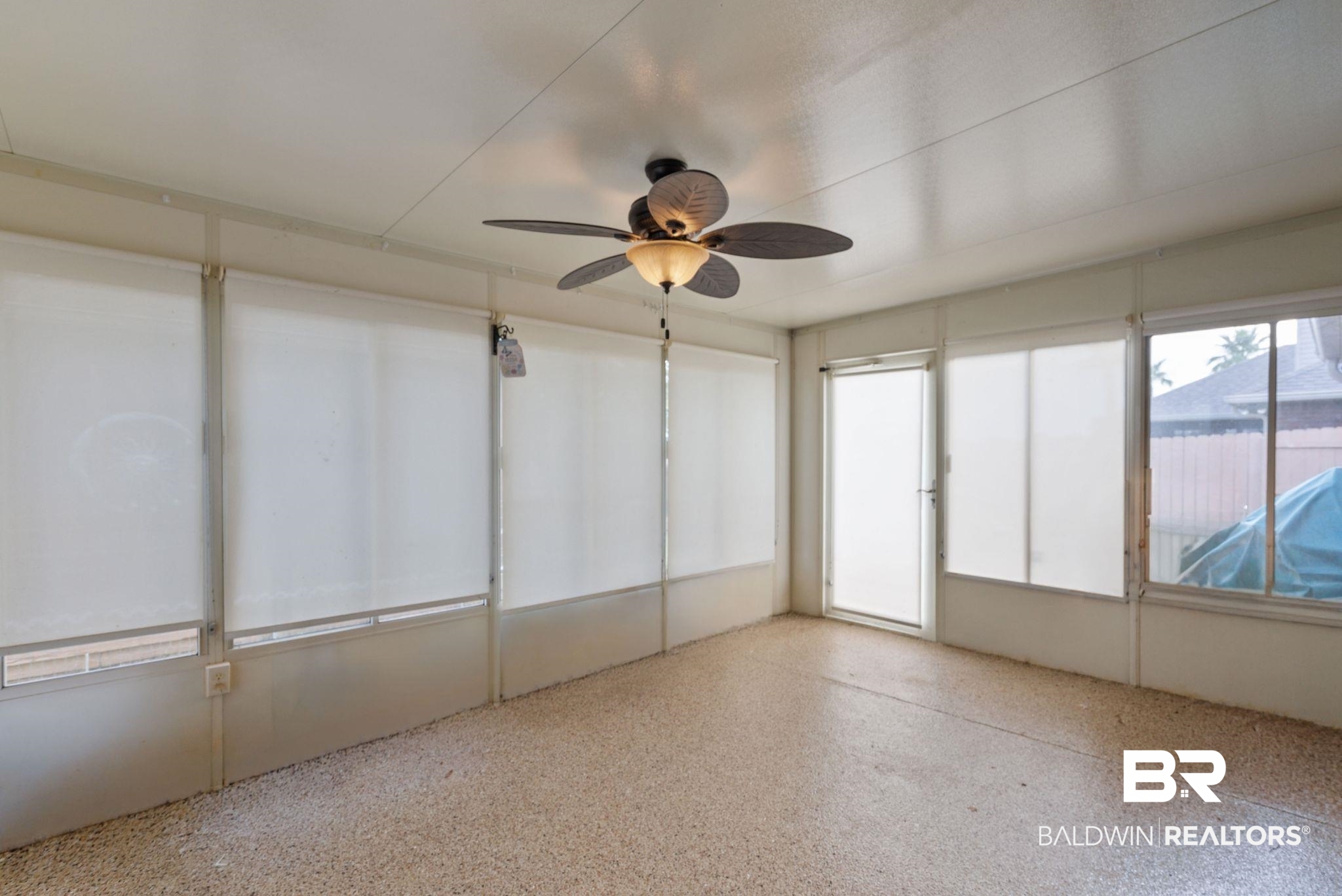 562 Vestige Mews Foley, AL 36535 - Photo 37 of 54 Enclosed sunroom featuring a ceiling fan with light fixture, multiple windows with roller shades, a glass-paneled entry door, and speckled floor surfacing