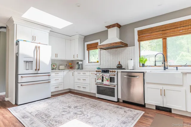a kitchen with white cabinets and appliances
