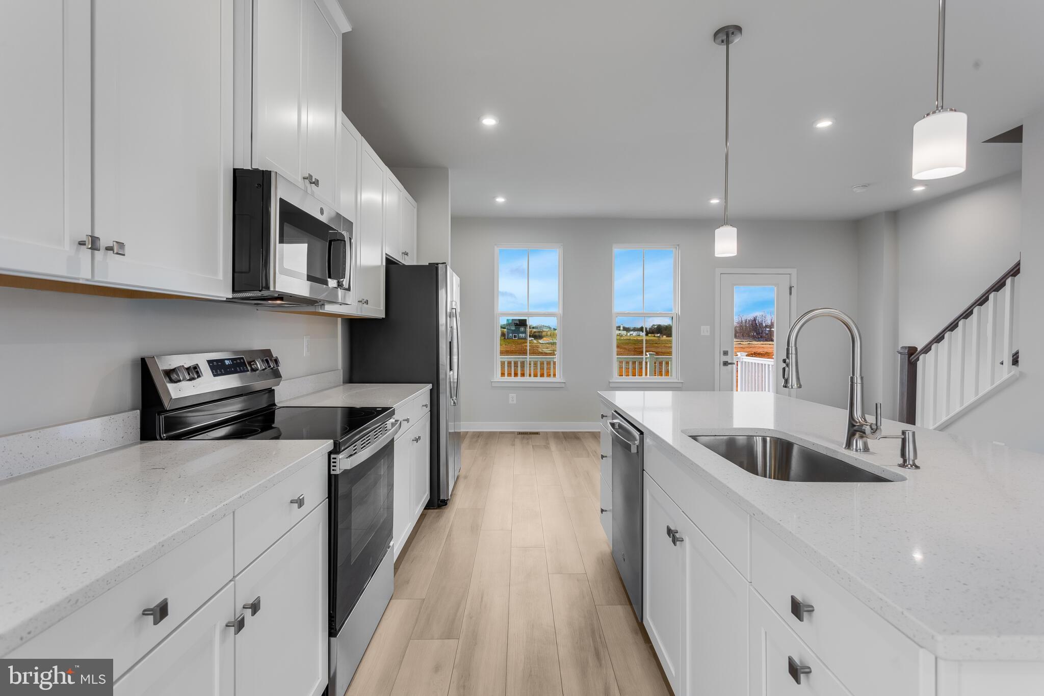 a kitchen with stainless steel appliances granite countertop a sink stove and cabinets