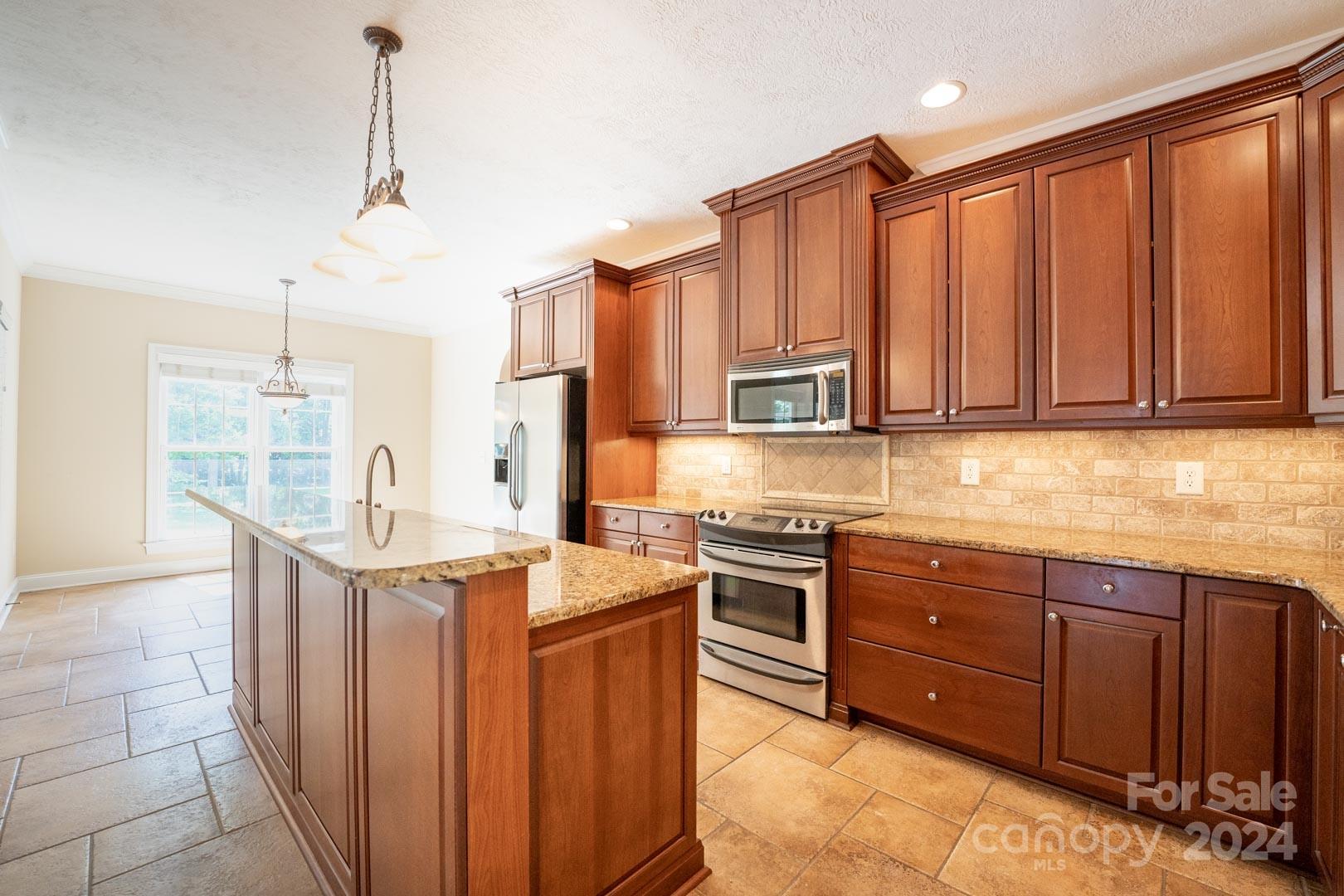 3563 Gordon Street Terrell, NC 28682 - Photo 29 of 45 a kitchen with stainless steel appliances granite countertop a sink a stove and a refrigerator