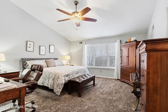 a bedroom with a bed and a refrigerator