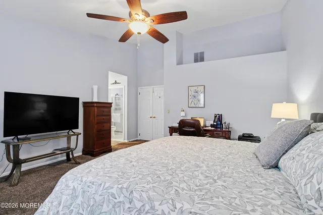 a bedroom with a bed and a flat tv screen on dresser