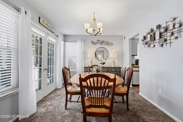 a view of a dining room with furniture and a chandelier
