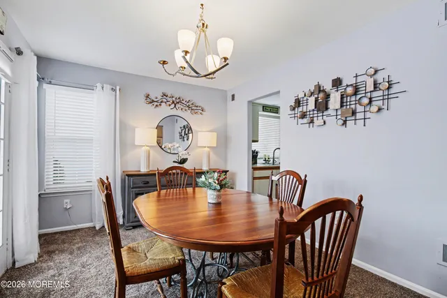 a view of a dining room with furniture and a chandelier