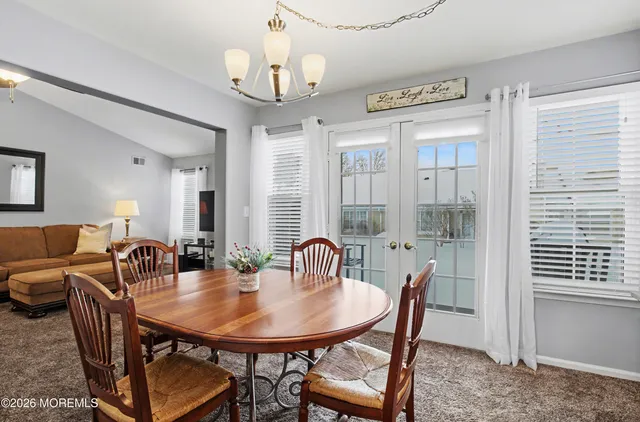a view of a a dining room with furniture window and wooden floor