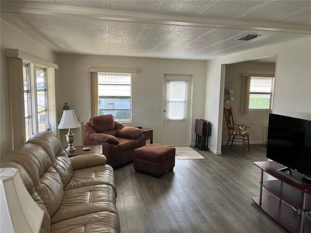 a living room with furniture a flat screen tv and wooden floor