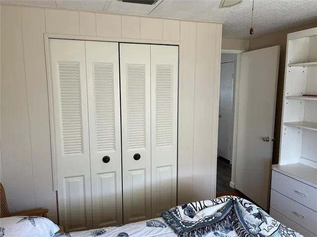 a view of a bedroom with a bed and wooden floor