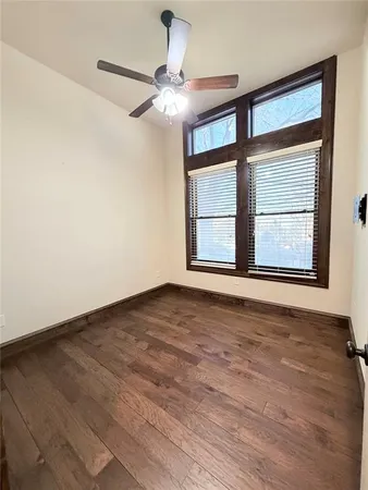 a view of an empty room with a window and wooden floor
