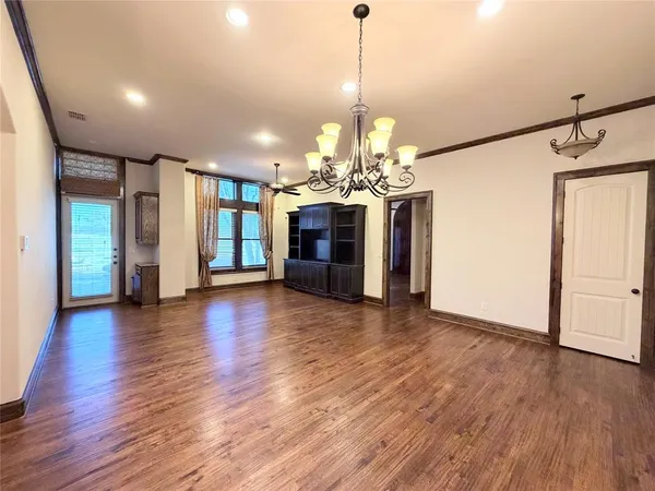 a view of a livingroom with a chandelier hardwood floor and a chandelier