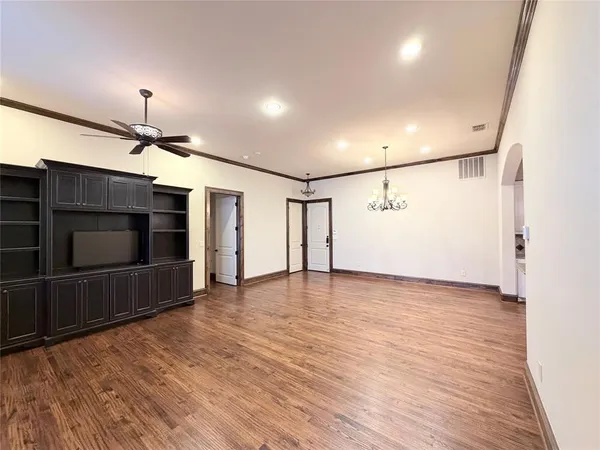 a view of empty room with wooden floor and fireplace
