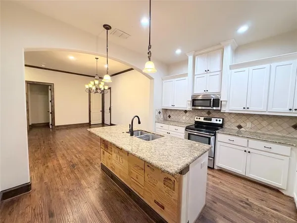 a kitchen with sink stove and wooden floor