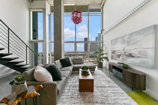 a living room with patio furniture and floor to ceiling windows