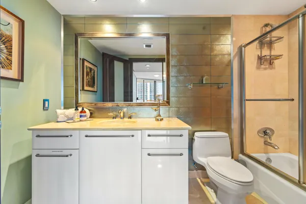 a bathroom with a double vanity sink a mirror a bathtub and shower