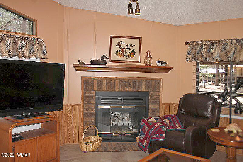 4260 West Blue Ridge Loop Pinetop, AZ 85935 - Photo 8 of 32 a living room with furniture a flat screen tv and a fireplace
