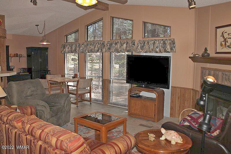 4260 West Blue Ridge Loop Pinetop, AZ 85935 - Photo 9 of 32 a living room with furniture a flat screen tv and kitchen view