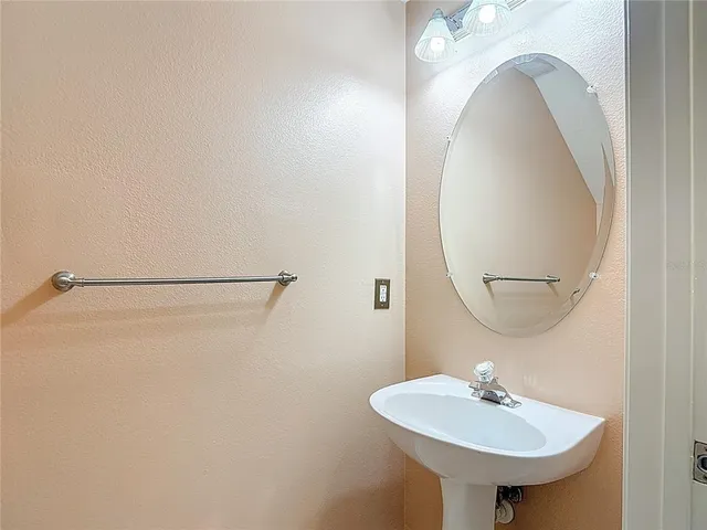 a bathroom with a sink a mirror and a light fixture