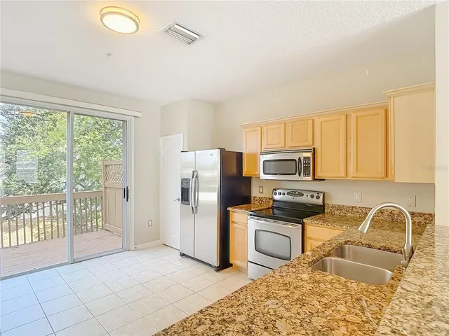 a kitchen with stainless steel appliances granite countertop a refrigerator stove top oven a sink and dishwasher