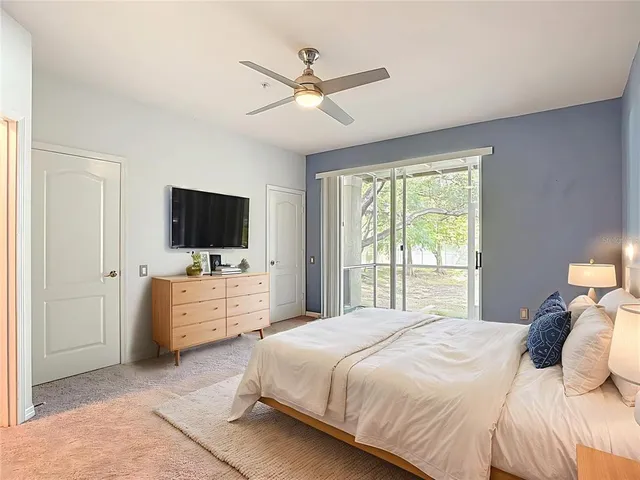 a bedroom with a bed flat screen tv and a window