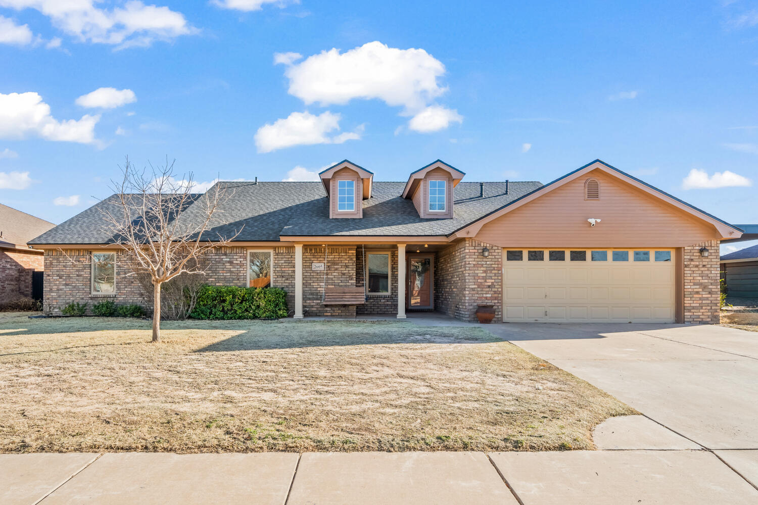 a front view of a house with a yard and a garage