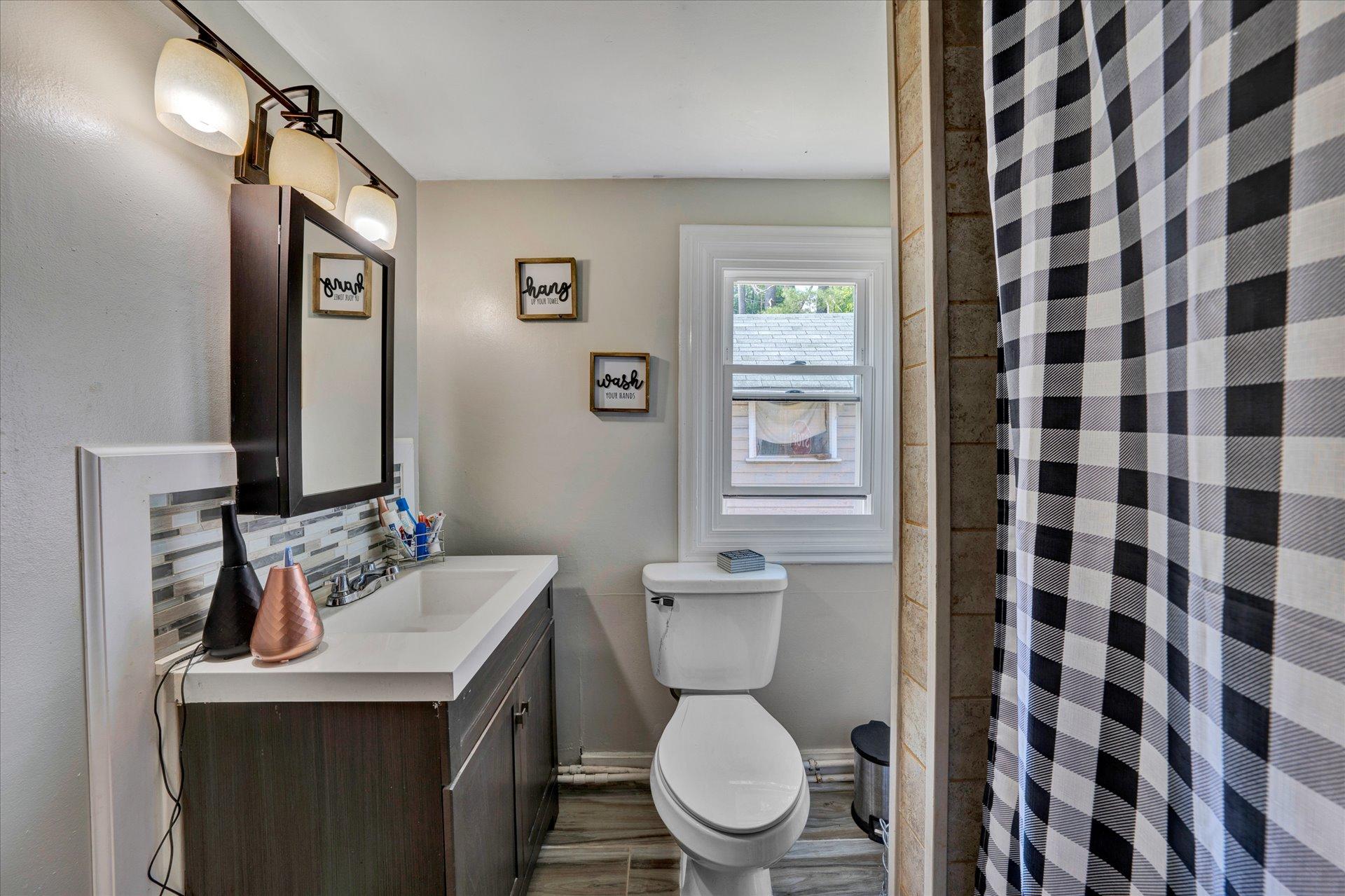 1344 Skyview Road Salem, VA 24153 - Photo 15 of 23 a bathroom with a sink a toilet and shower curtain